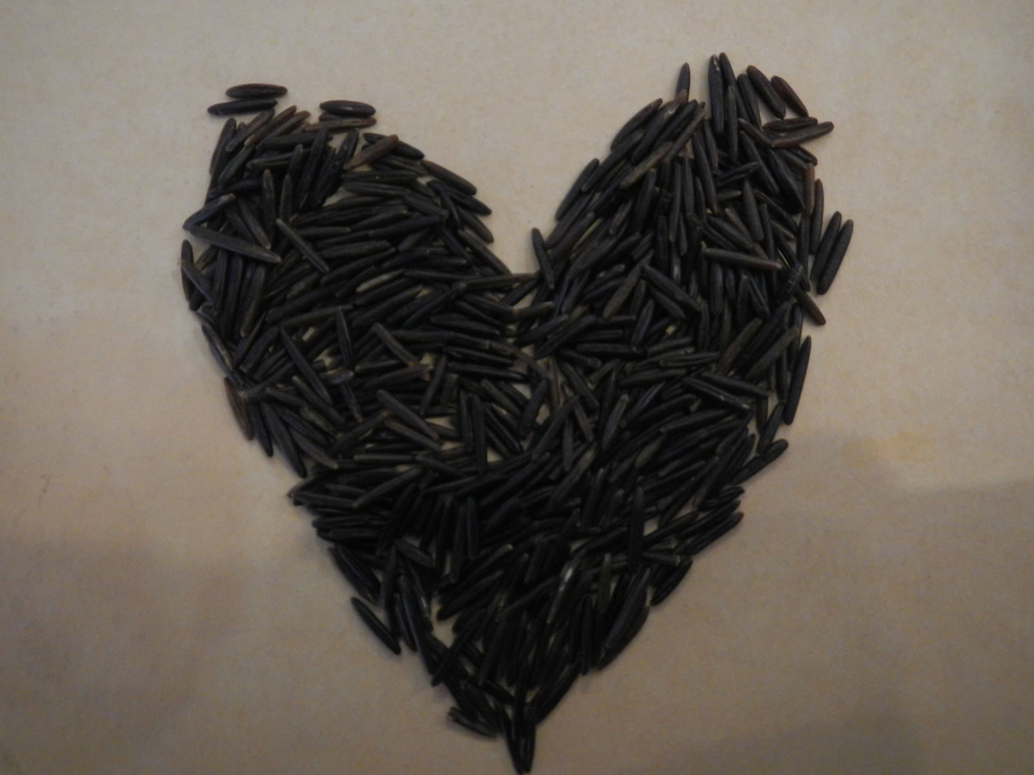 Image shows a heart-shaped pile of wild rice.
